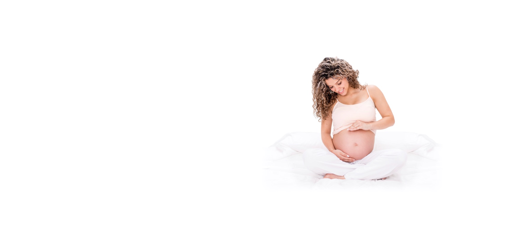 Gravid kvinna i ljusa kläder som håller om magen mot vit bakgrund